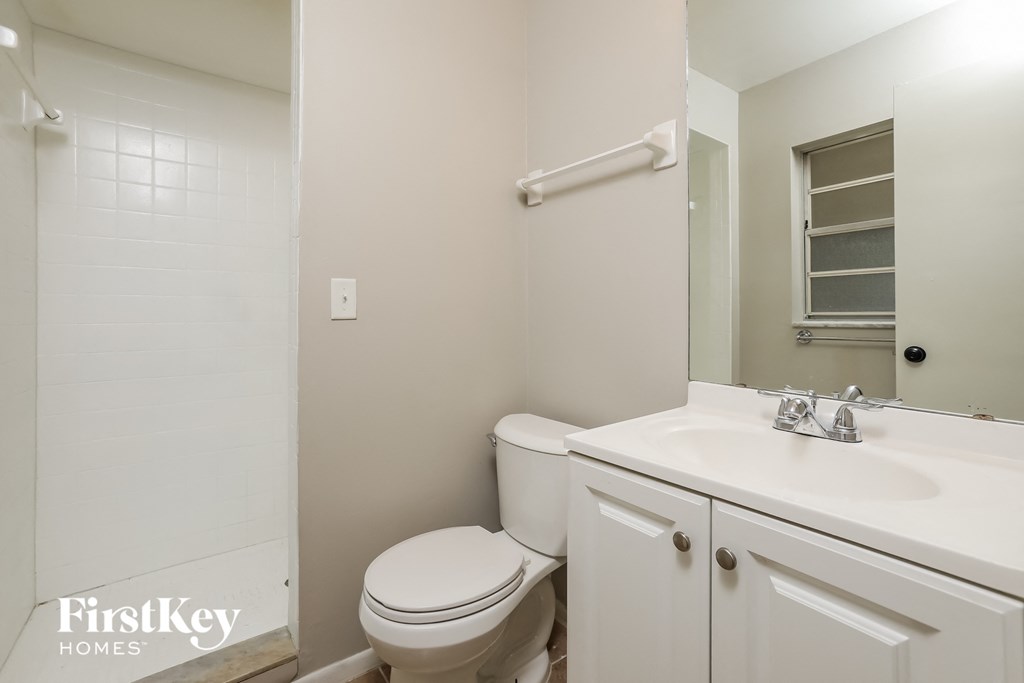 a bathroom with a toilet and a sink and a mirror