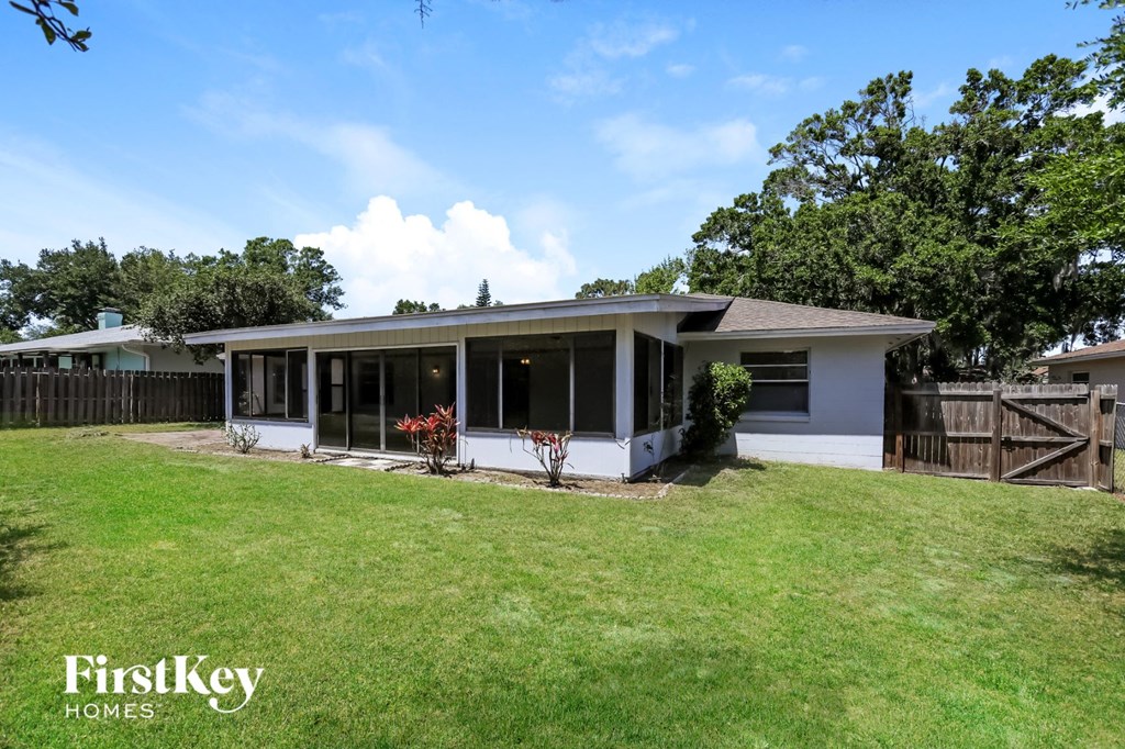a small white house with a yard and a fence
