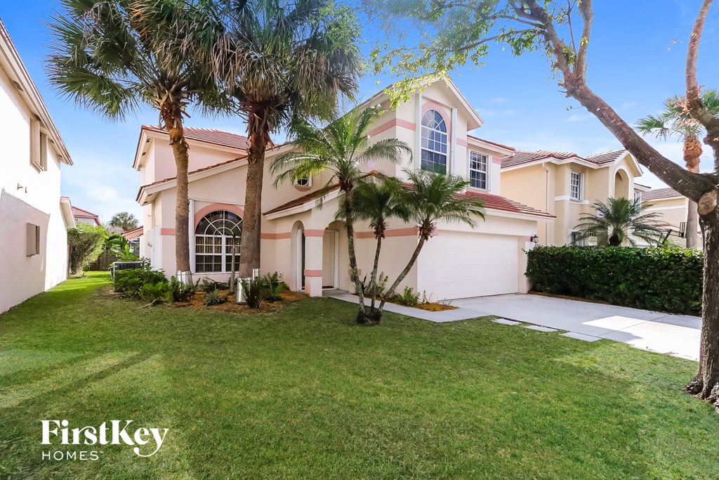 A house with a palm tree in front of it.