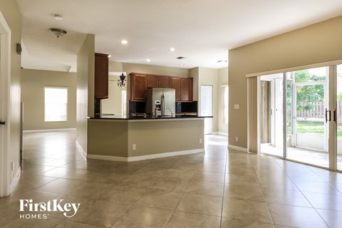 A spacious kitchen with a bar area and a view of the backyard.