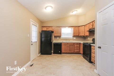 A kitchen with a black fridge, black dishwasher and black oven.