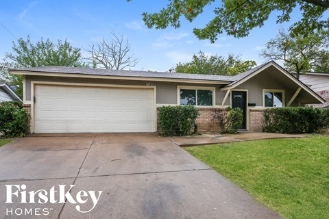 a home with a driveway and a white garage door