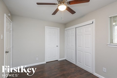 a bedroom with two closets and a ceiling fan