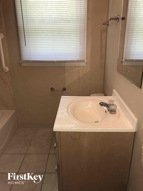 a small bathroom with a sink and a tub and a window