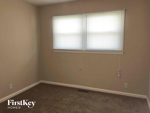 a room with a window and a carpeted floor