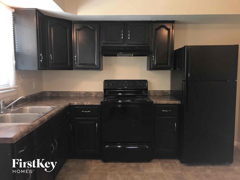 a kitchen with black appliances and black cabinets