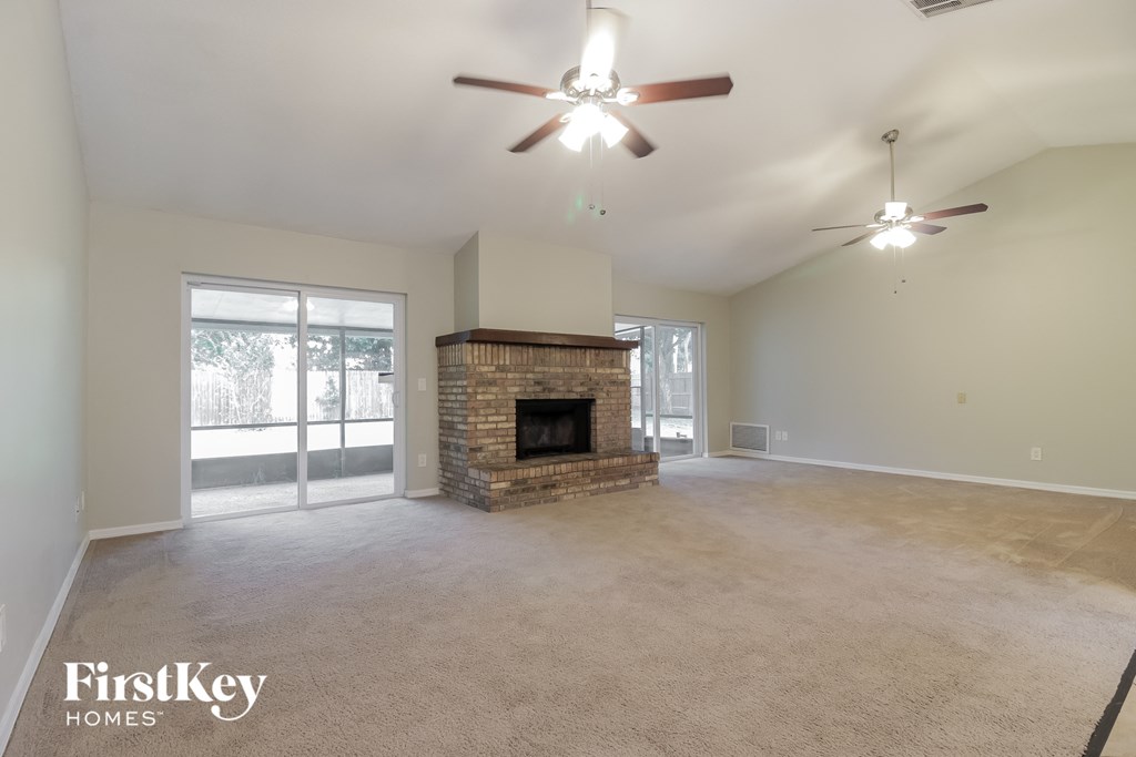 a living room with a fireplace and a ceiling fan