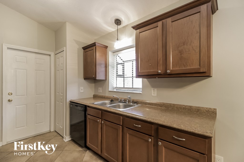 a kitchen with wooden cabinets and a sink and a window