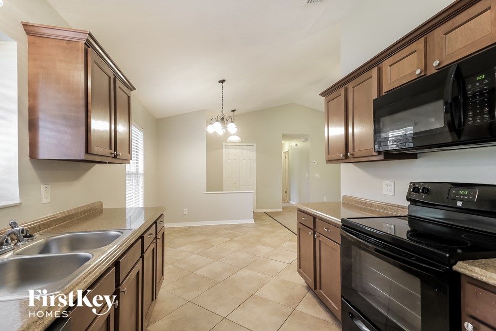 a kitchen with black appliances and wooden cabinets