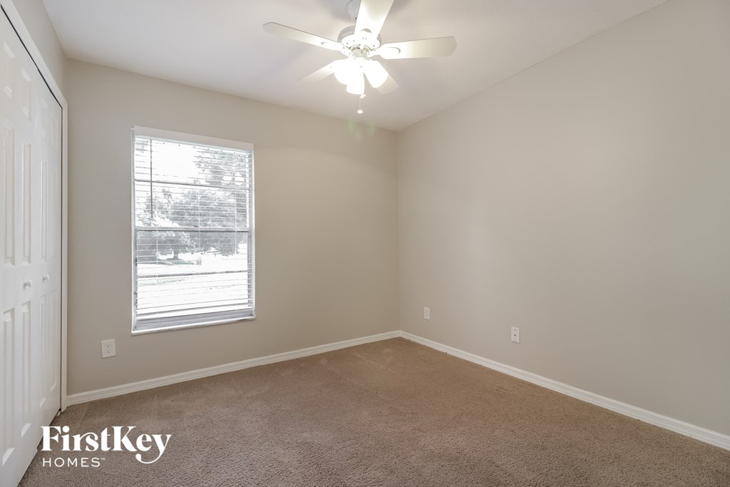a bedroom with a ceiling fan and a window