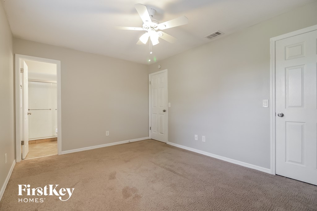 a bedroom with a carpeted floor and a ceiling fan