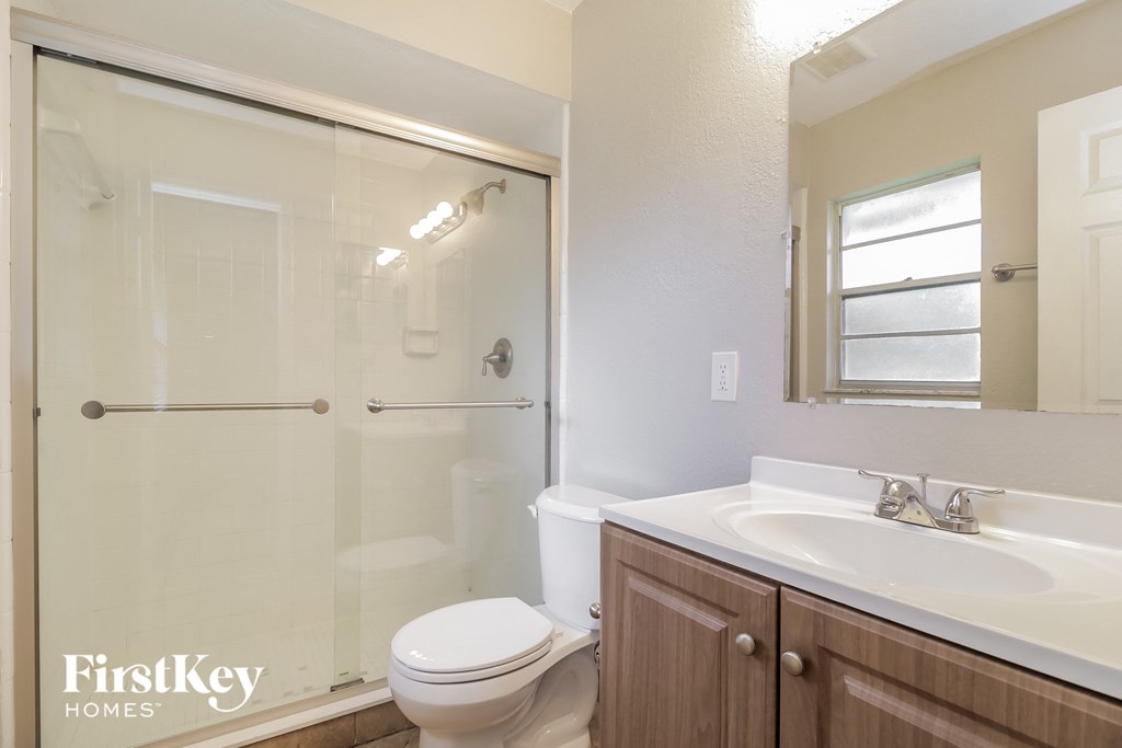 a bathroom with a shower toilet and sink and a mirror