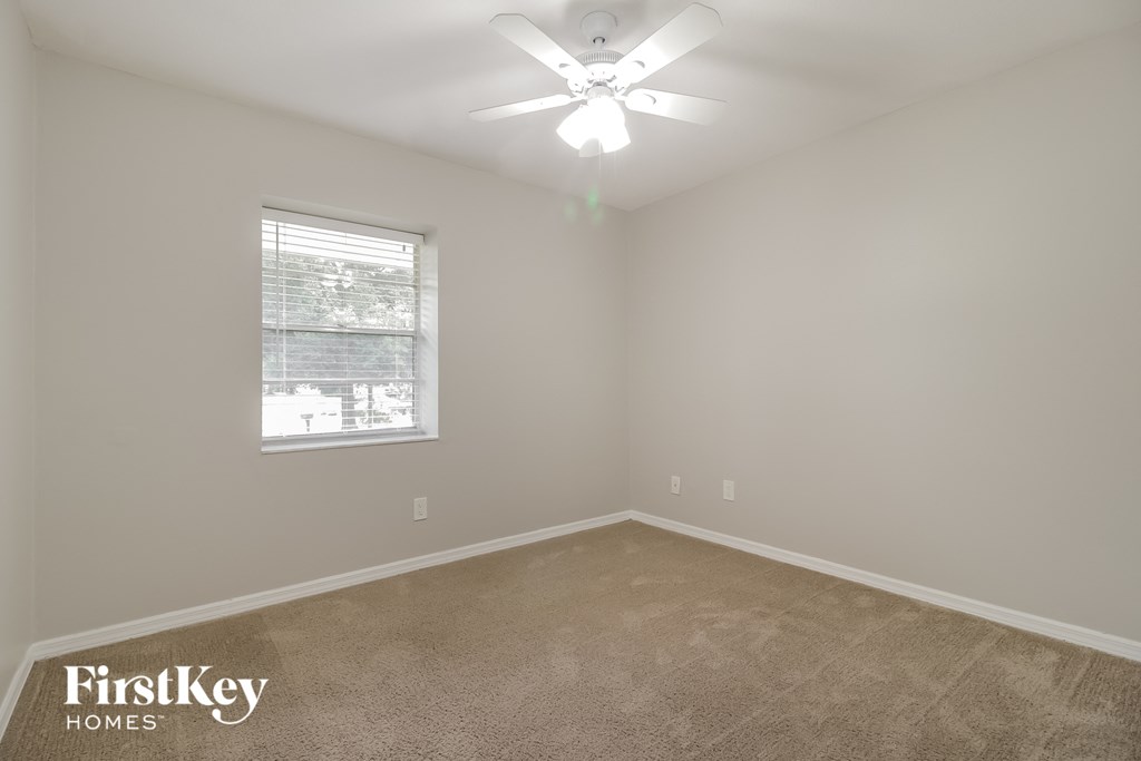 a bedroom with a ceiling fan and a window