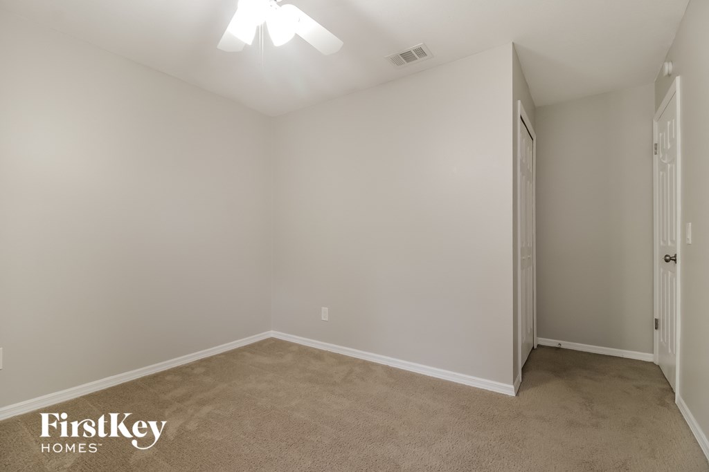 a bedroom with a carpeted floor and a door to a closet