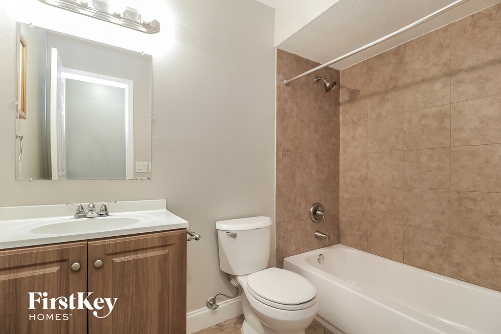 a bathroom with a toilet sink and tub and a mirror