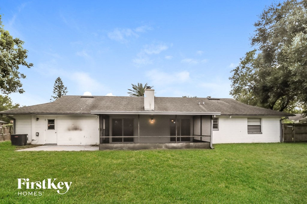 the back of a white house with a grassy yard