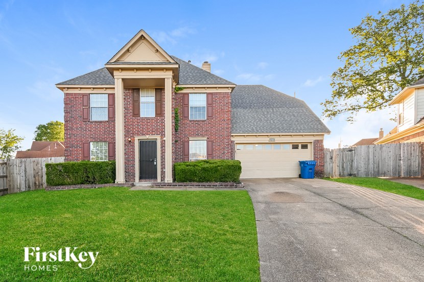 A brick house with a black door and a garage.