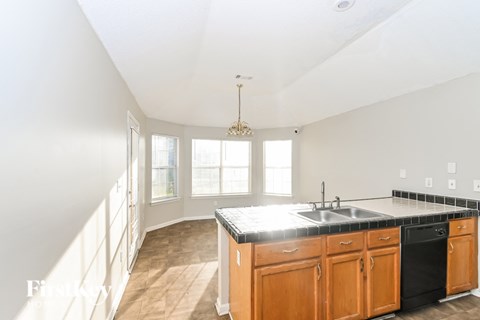 A kitchen with wooden cabinets and a black countertop.