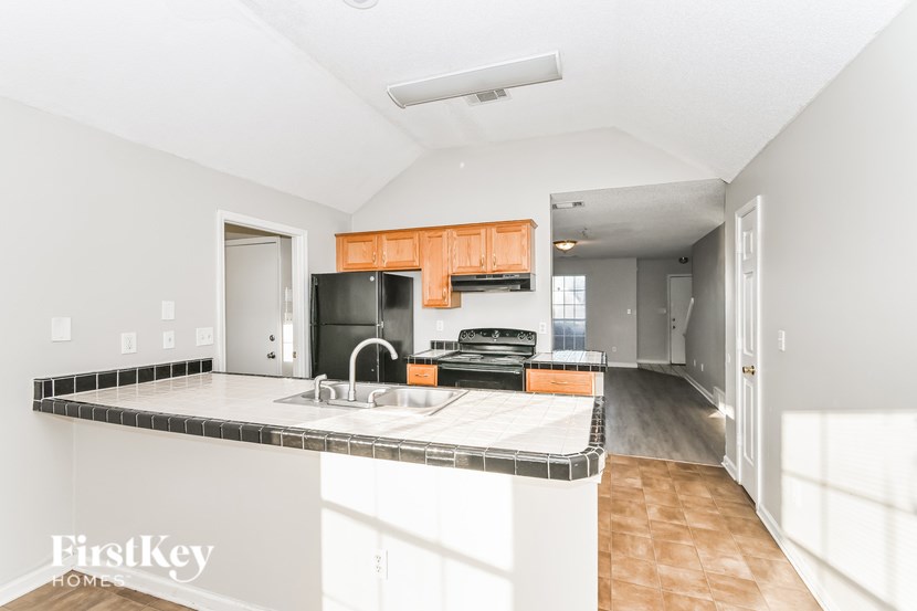 A kitchen with a sink and a refrigerator.