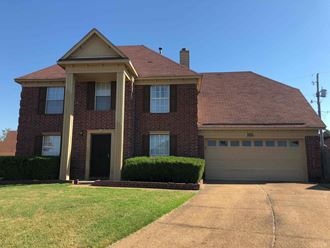 a large brick house with a driveway and a garage door