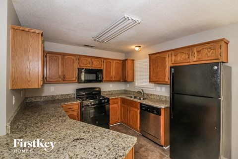 A kitchen with wooden cabinets and granite countertops.