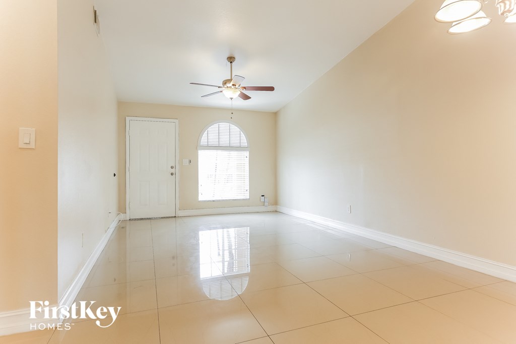 A spacious room with a ceiling fan and a window.