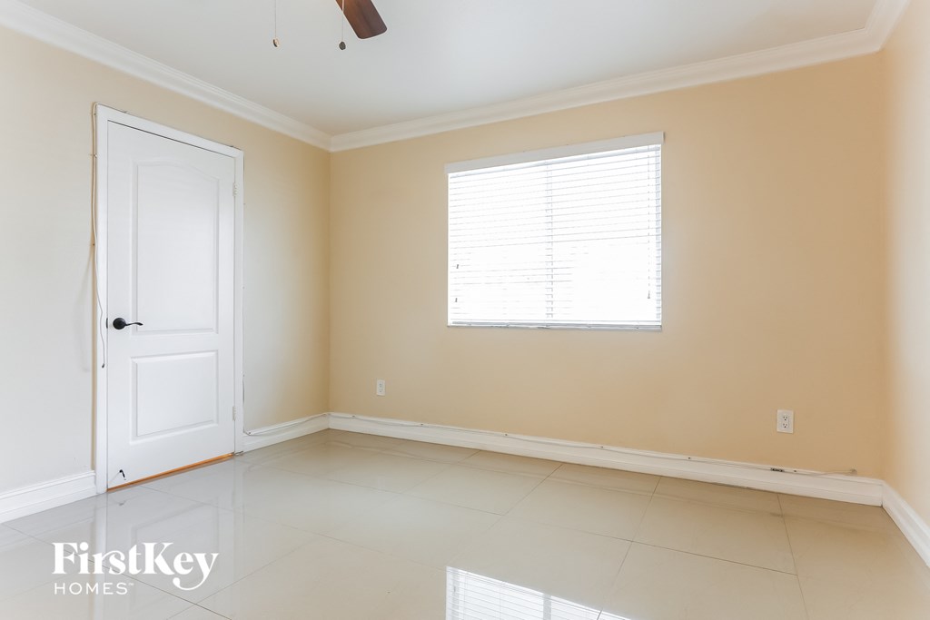 A room with a white door and a window with blinds.