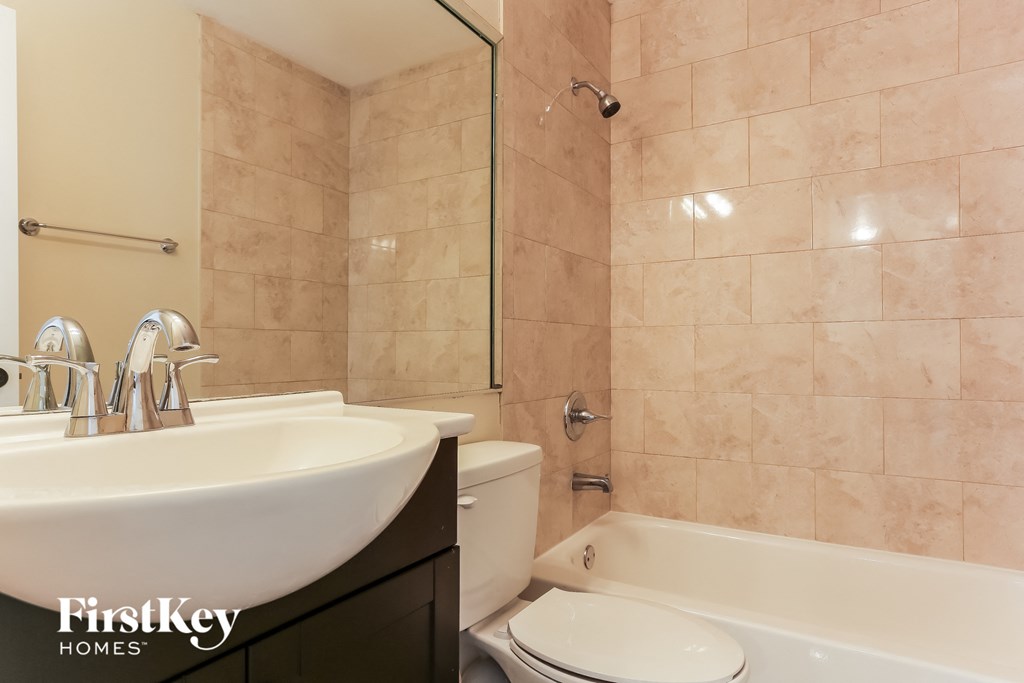A bathroom with a sink, toilet, and bathtub.