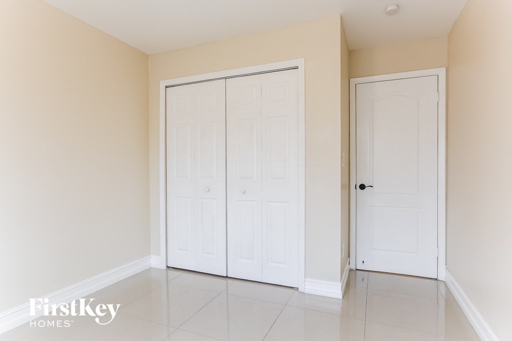 A room with two white doors and a white floor.