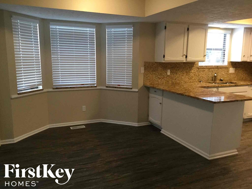 an empty kitchen with a counter top and a sink