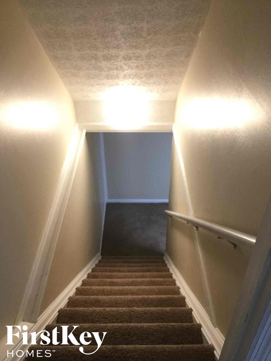 a stairway leading up to a staircase with a light on the side of it
