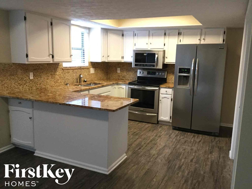 a kitchen with stainless steel appliances and white cabinets