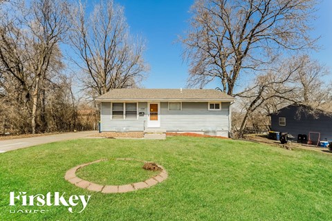 A house with a well-maintained lawn and a circular garden bed in the front yard.