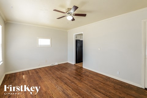 A room with a wood floor and a ceiling fan.