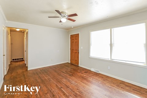 A room with wooden floors and a ceiling fan.