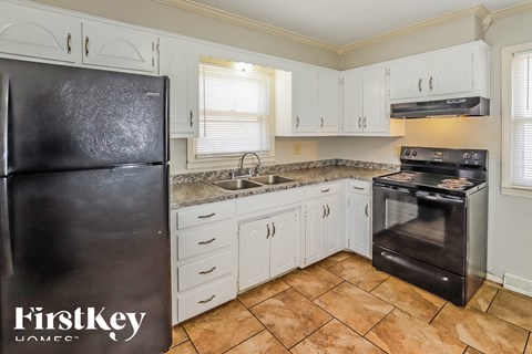 A kitchen with a black fridge and a black oven.