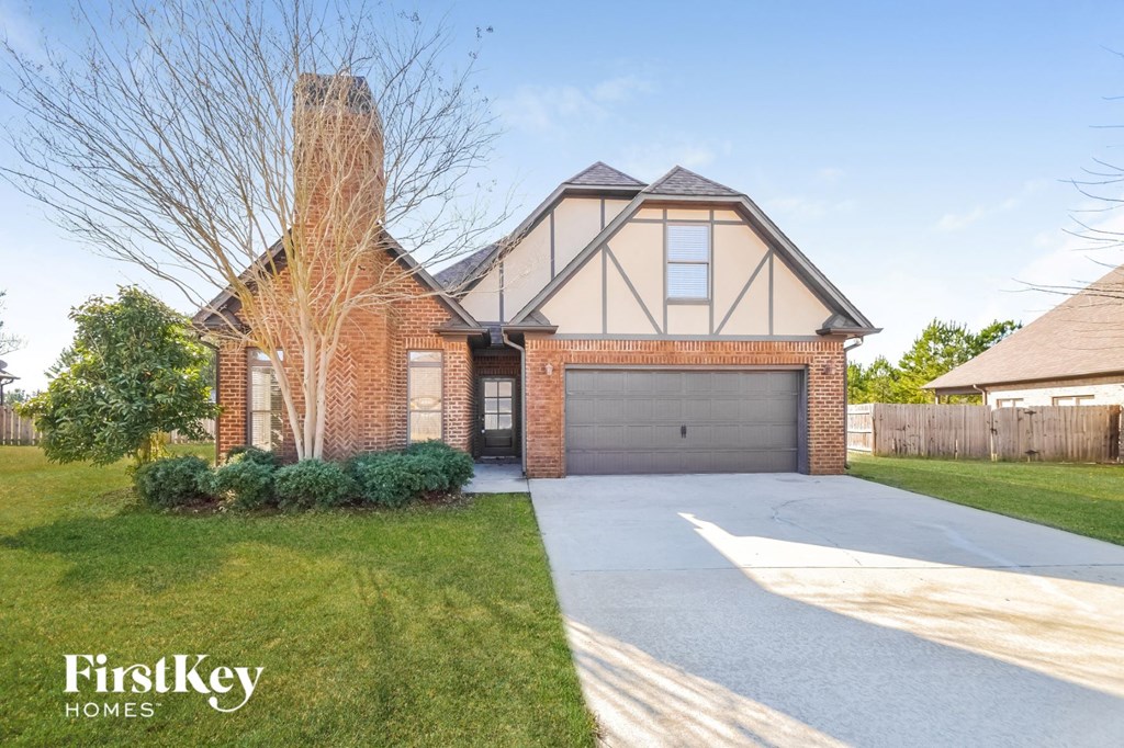 A brick house with a garage door and a chimney.