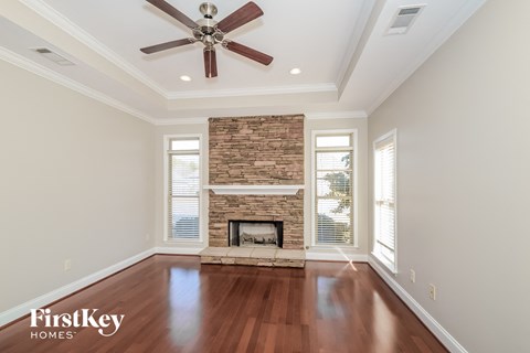 A spacious room with a fireplace and a ceiling fan.