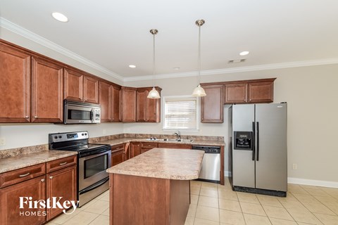 A kitchen with wooden cabinets and a granite countertop.