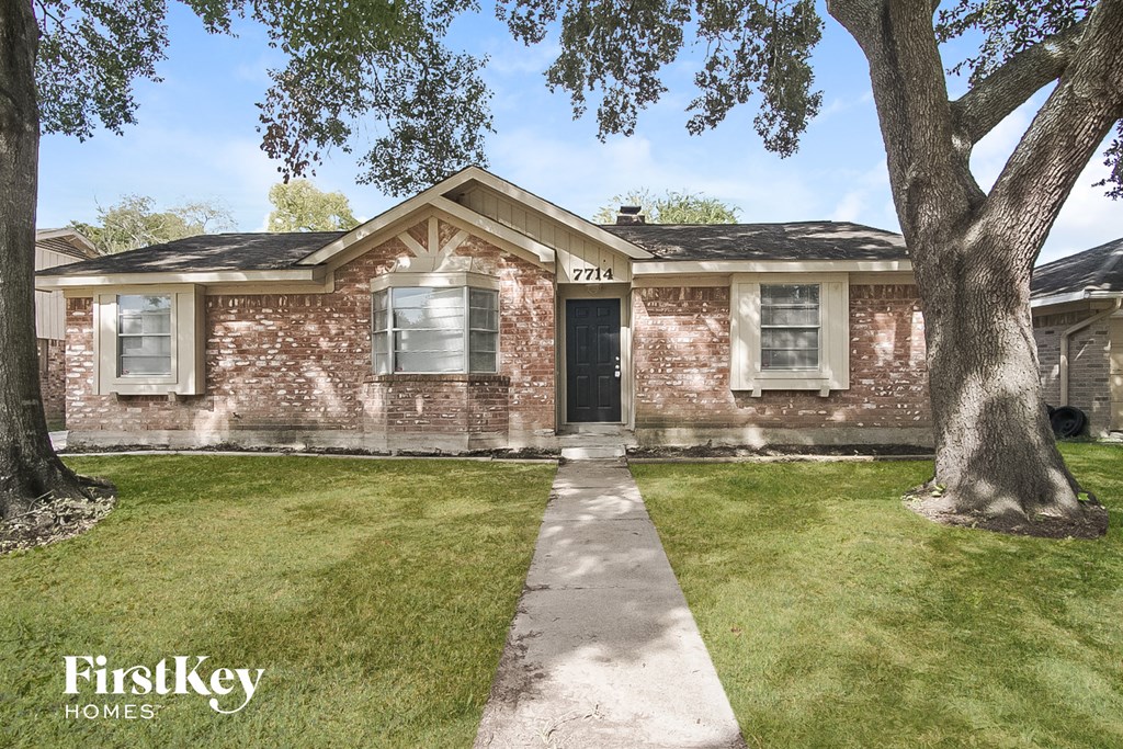 a brick house with a sidewalk in front of it