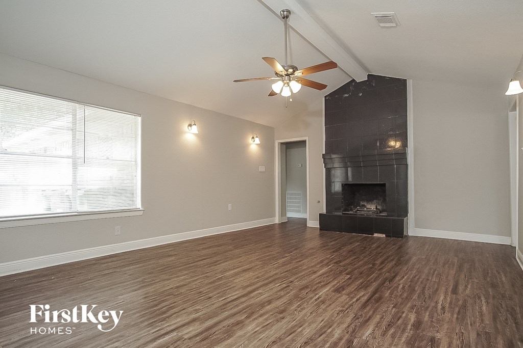 a living room with a fireplace and a ceiling fan