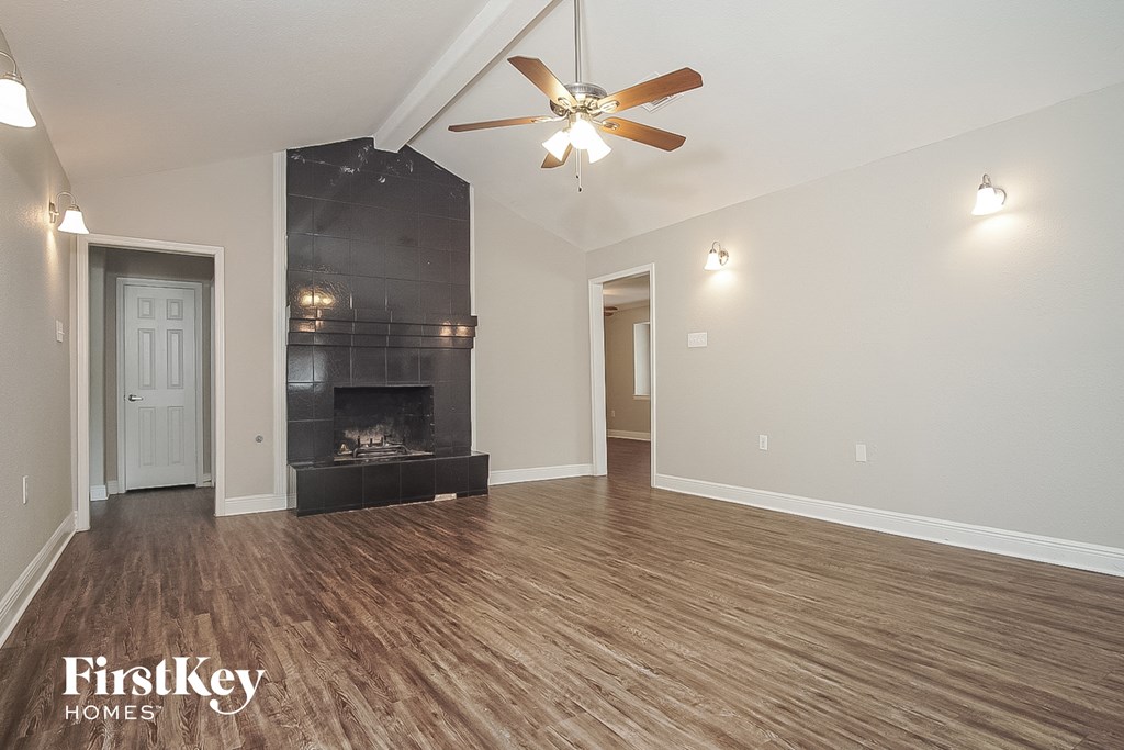 a living room with a fireplace and a ceiling fan