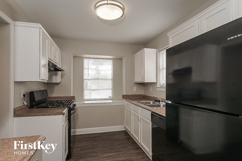 a kitchen with black appliances and white cabinets