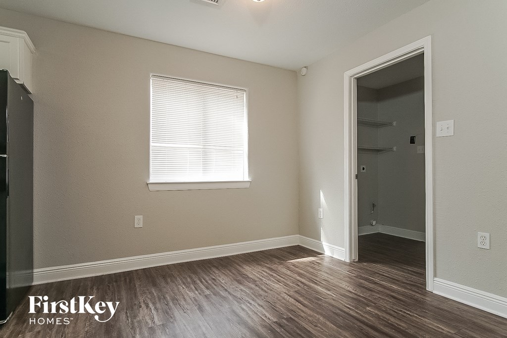 a living room with a door to a closet and a window