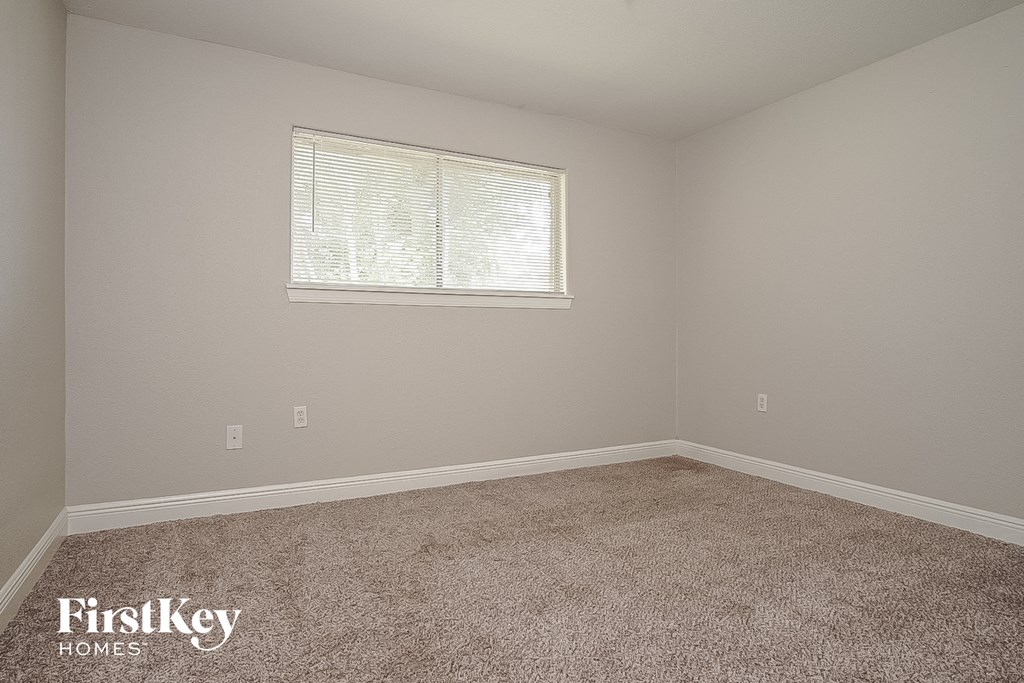 a bedroom with carpet and a window