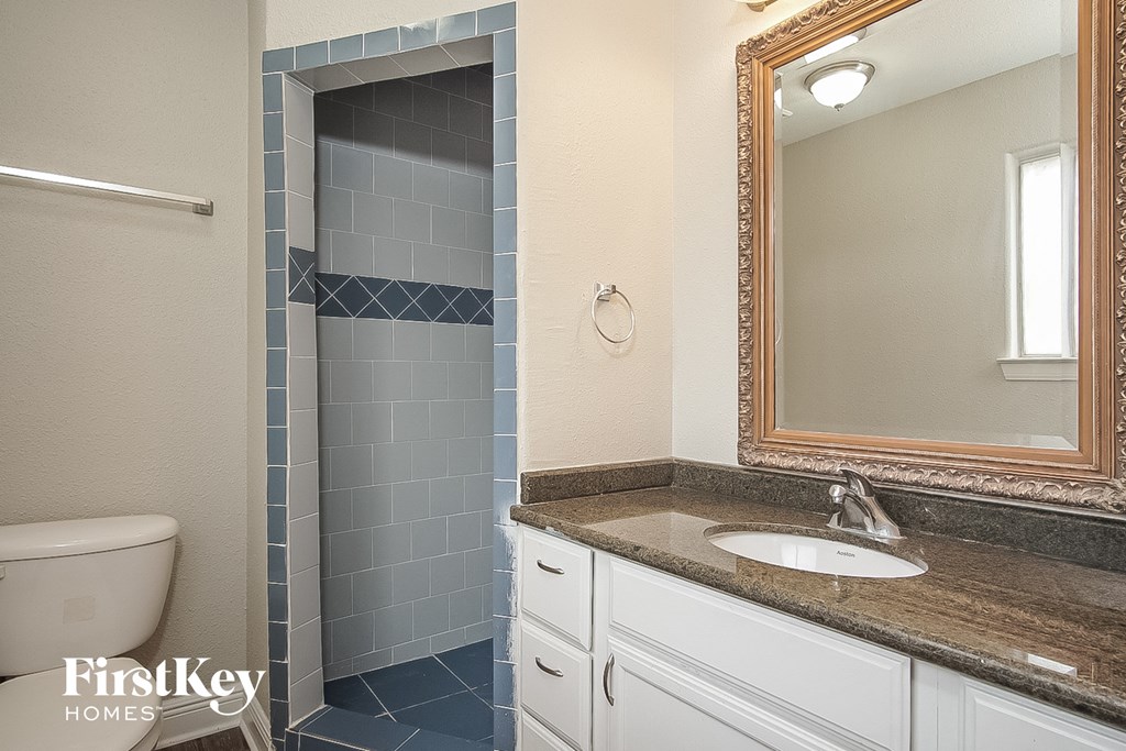 a bathroom with a toilet and a sink and a mirror