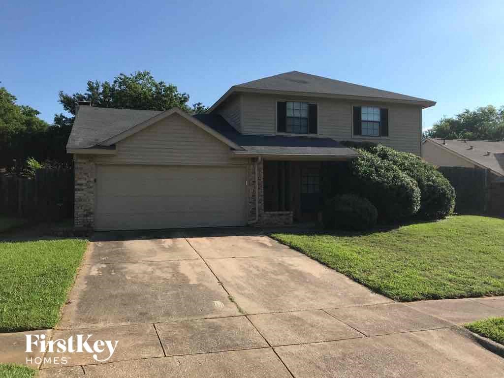 A house with a garage and a driveway is for sale.