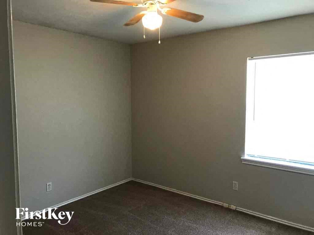 A room with a ceiling fan and a window.