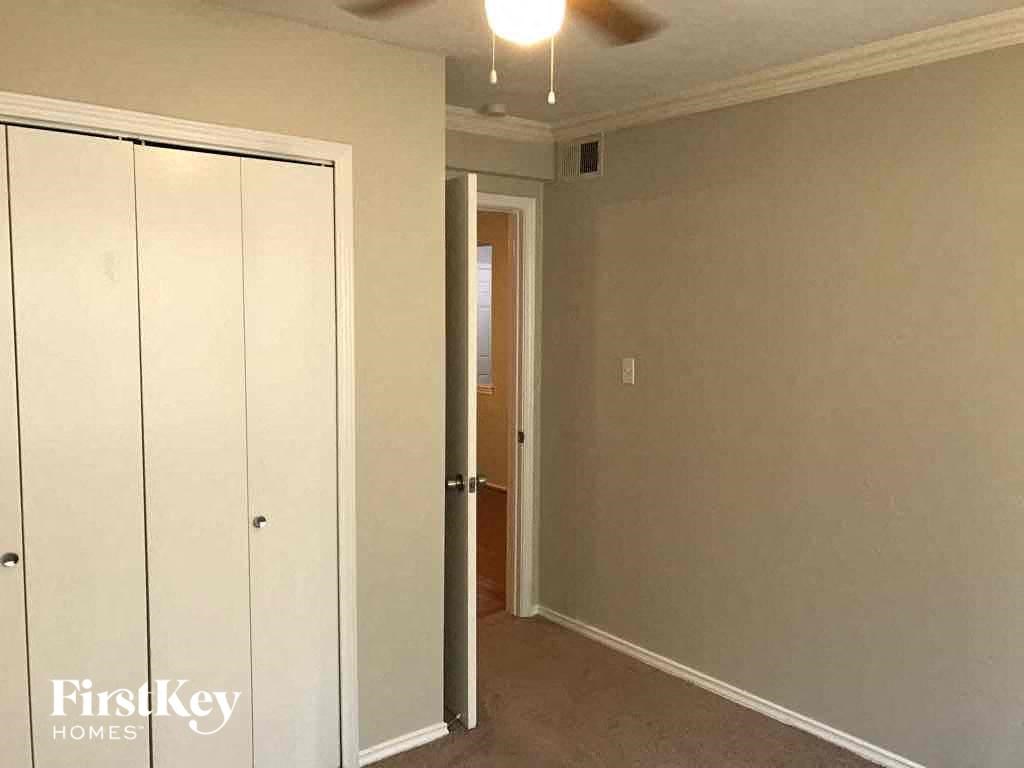 A room with a white closet and a ceiling fan.