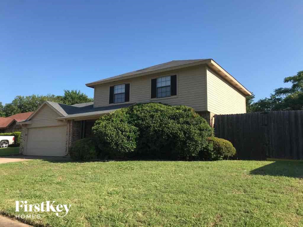 A house with a garage and a fence in front of it.